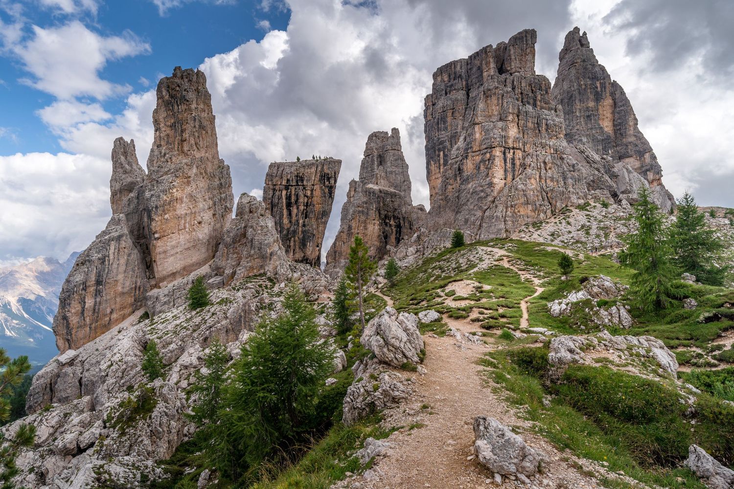 Hiking trail leading up to the towering mountain range of the Dolomites, Italy.