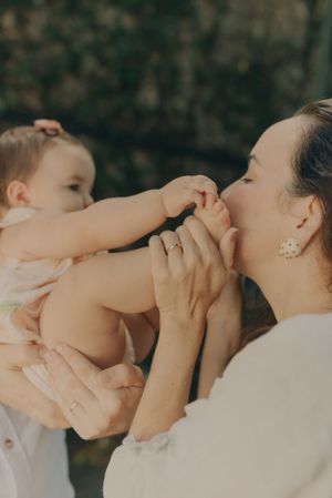 A tender moment between parent and baby as tiny fingers reach up playfully.
