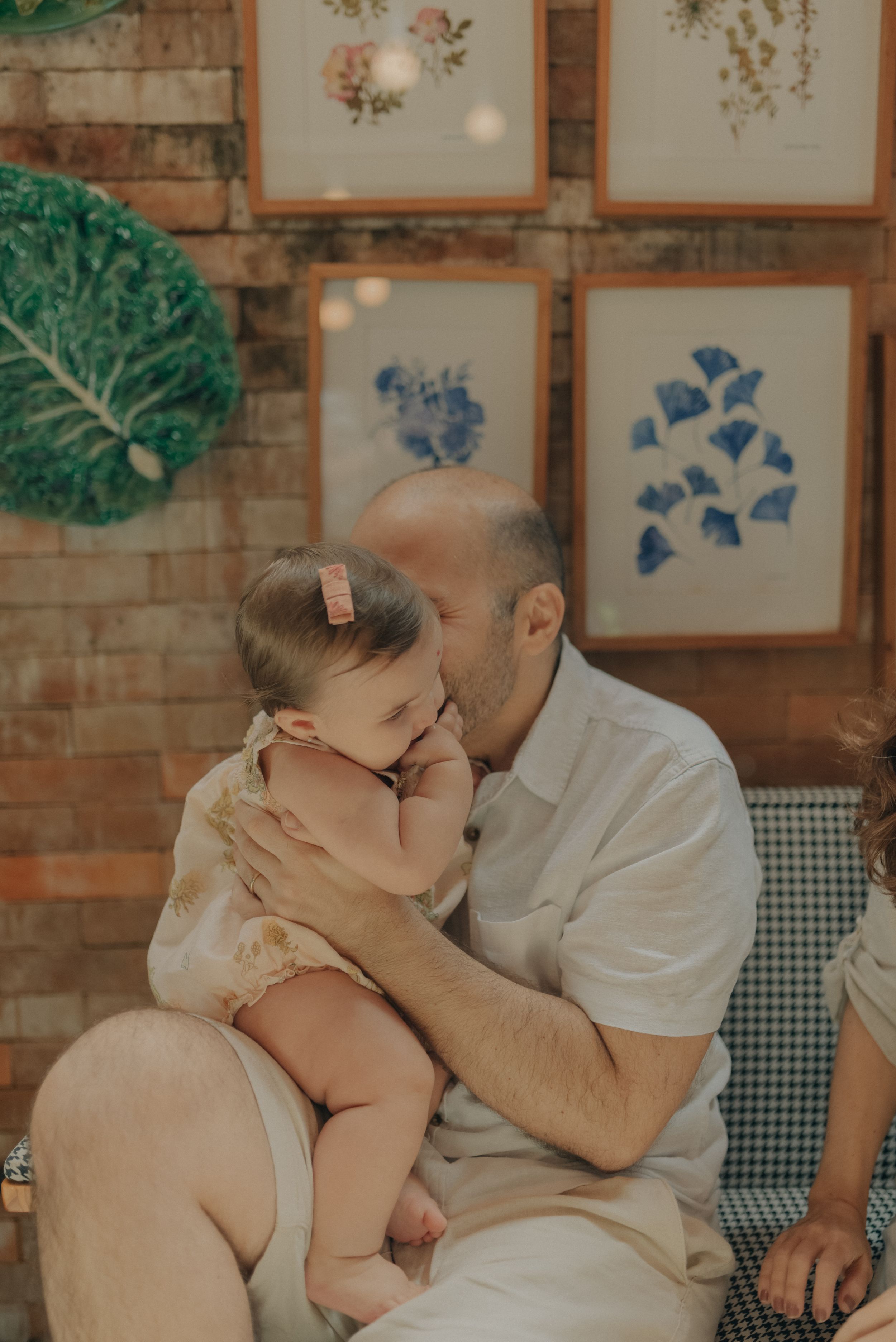 Intimate family moment on a chair with decorative artwork in background.