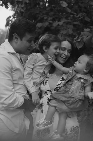 Black and white outdoor family portrait showing joyful interaction among family members.
