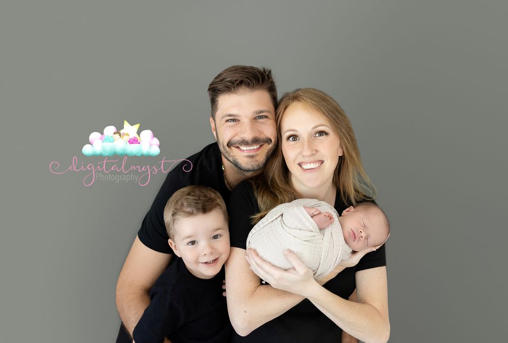 Family portrait session on grey background showing loving embrace.