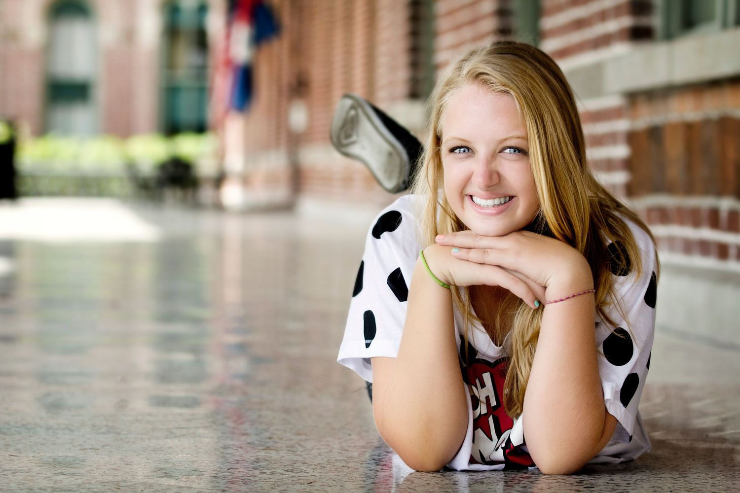 Girl in white and black polka dot shirt playfully smiling at the camera at University of Tampa.