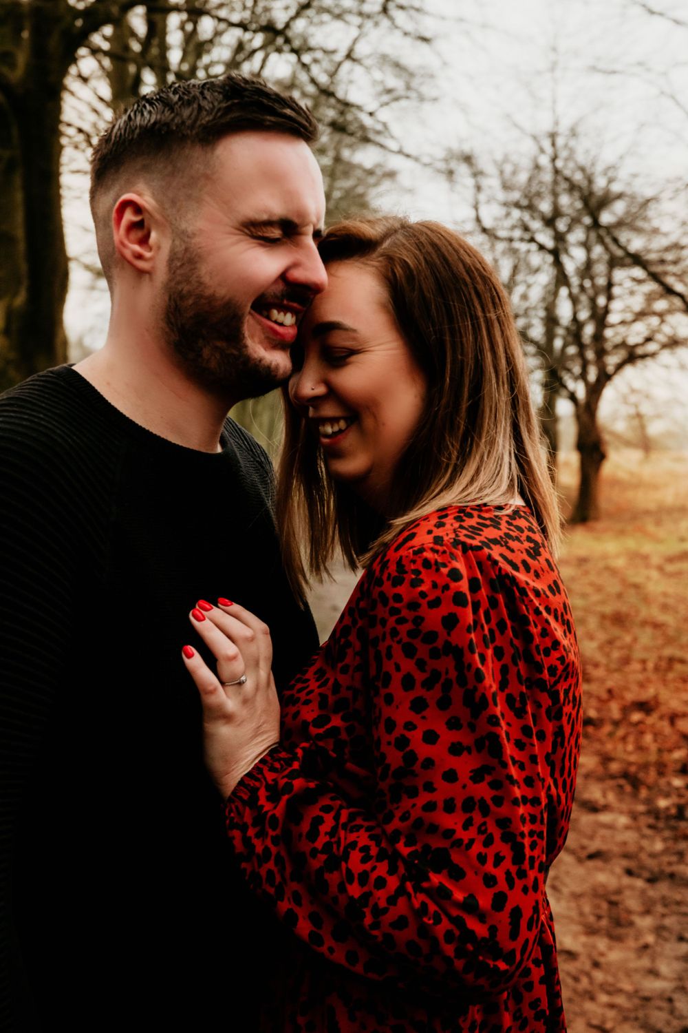Couple sharing a joyful moment outdoors wearing casual autumn attire.