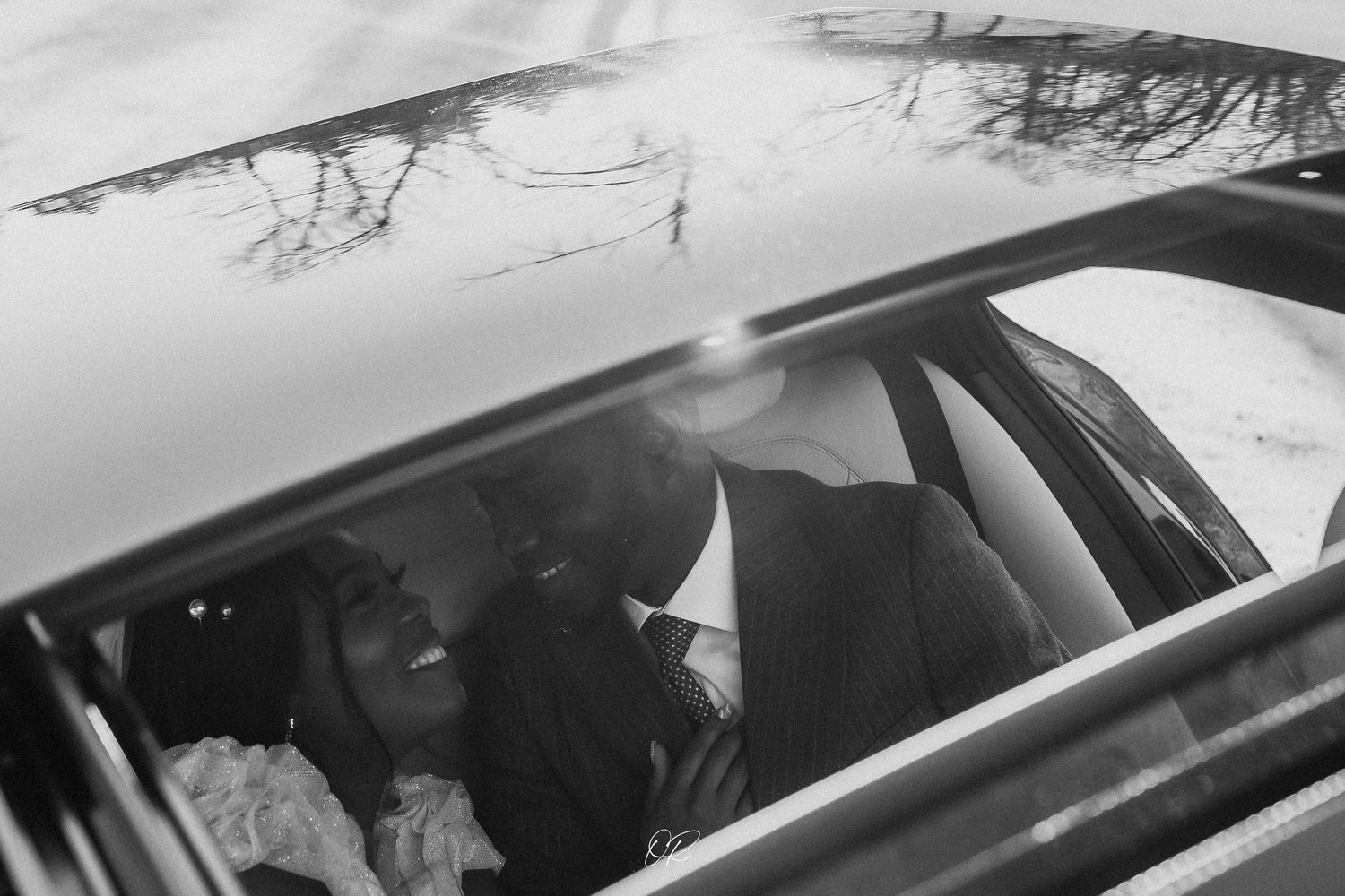 A candid moment captured through a car window in black and white photography.