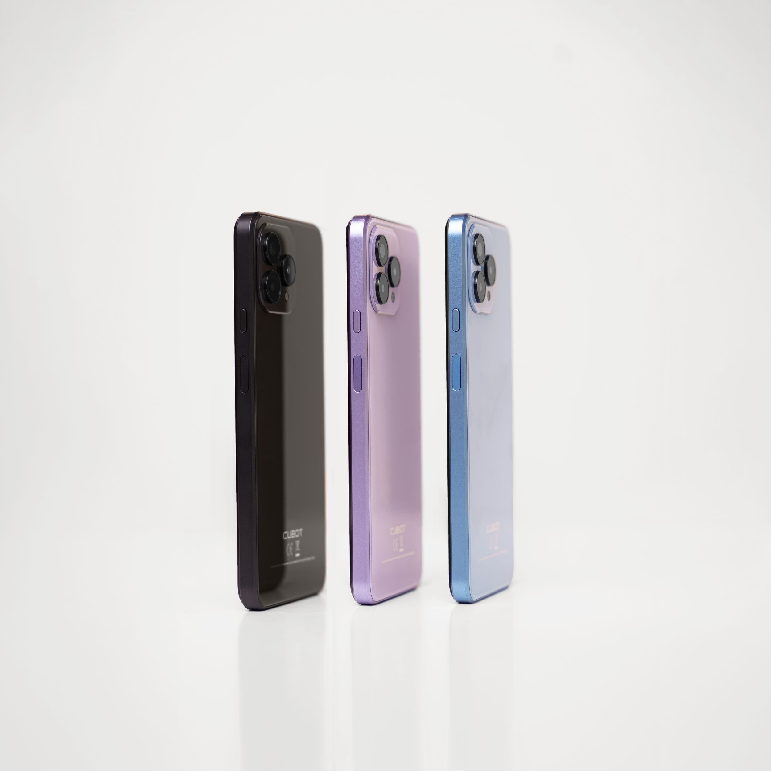 Three smartphones displayed in black, purple, and blue colors showing their rear views against a white background.