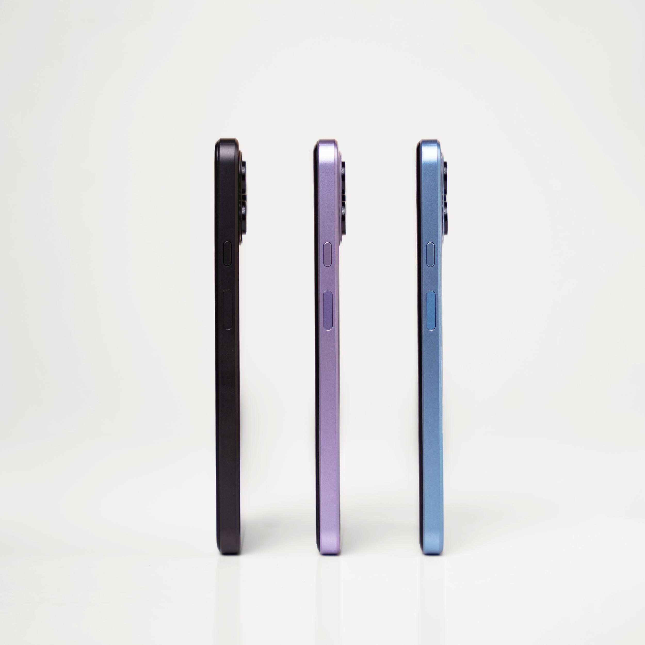 Side view comparison of three smartphones in black, purple, and blue colors.