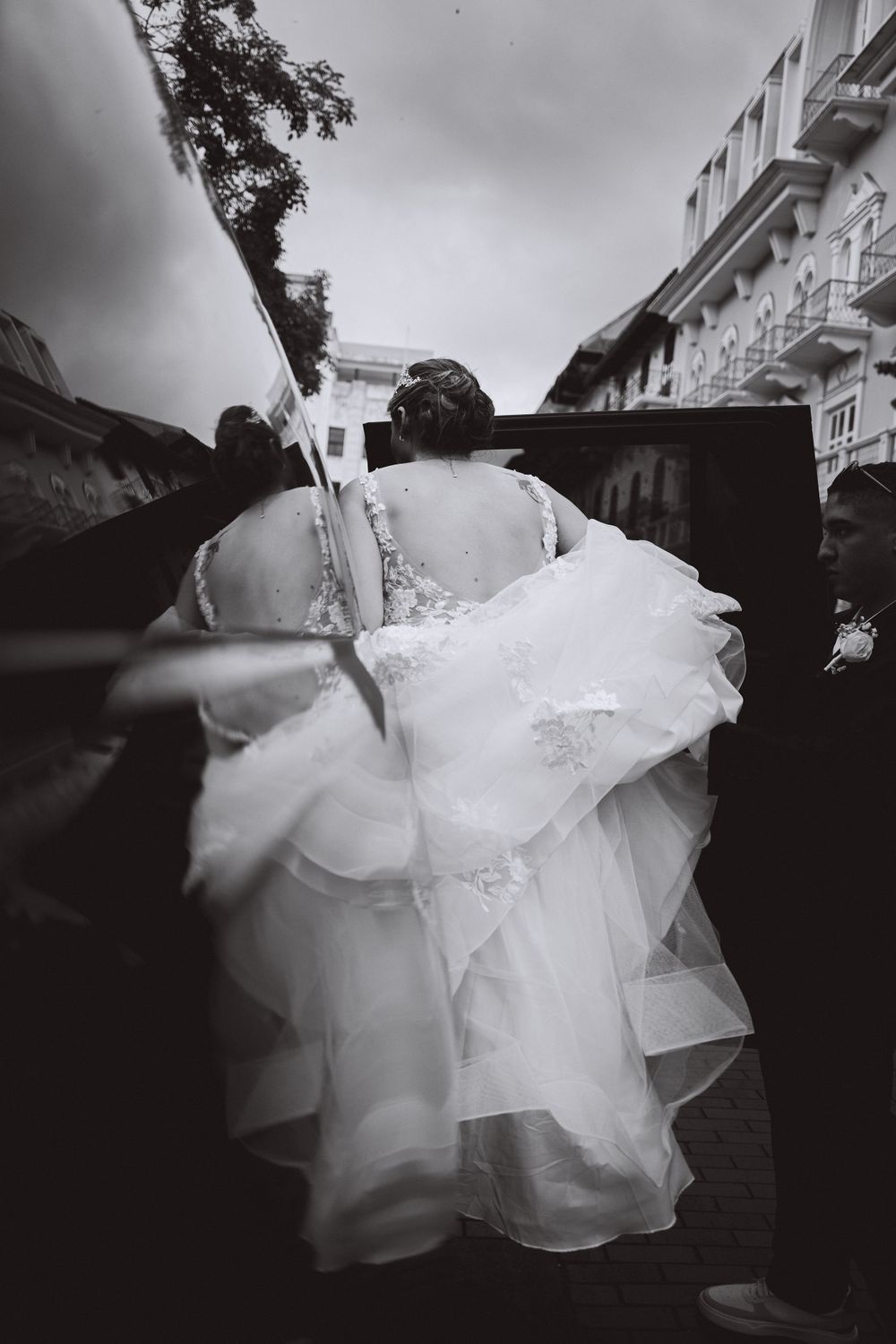 A black and white photo captures the flowing movement of a wedding dress from behind.