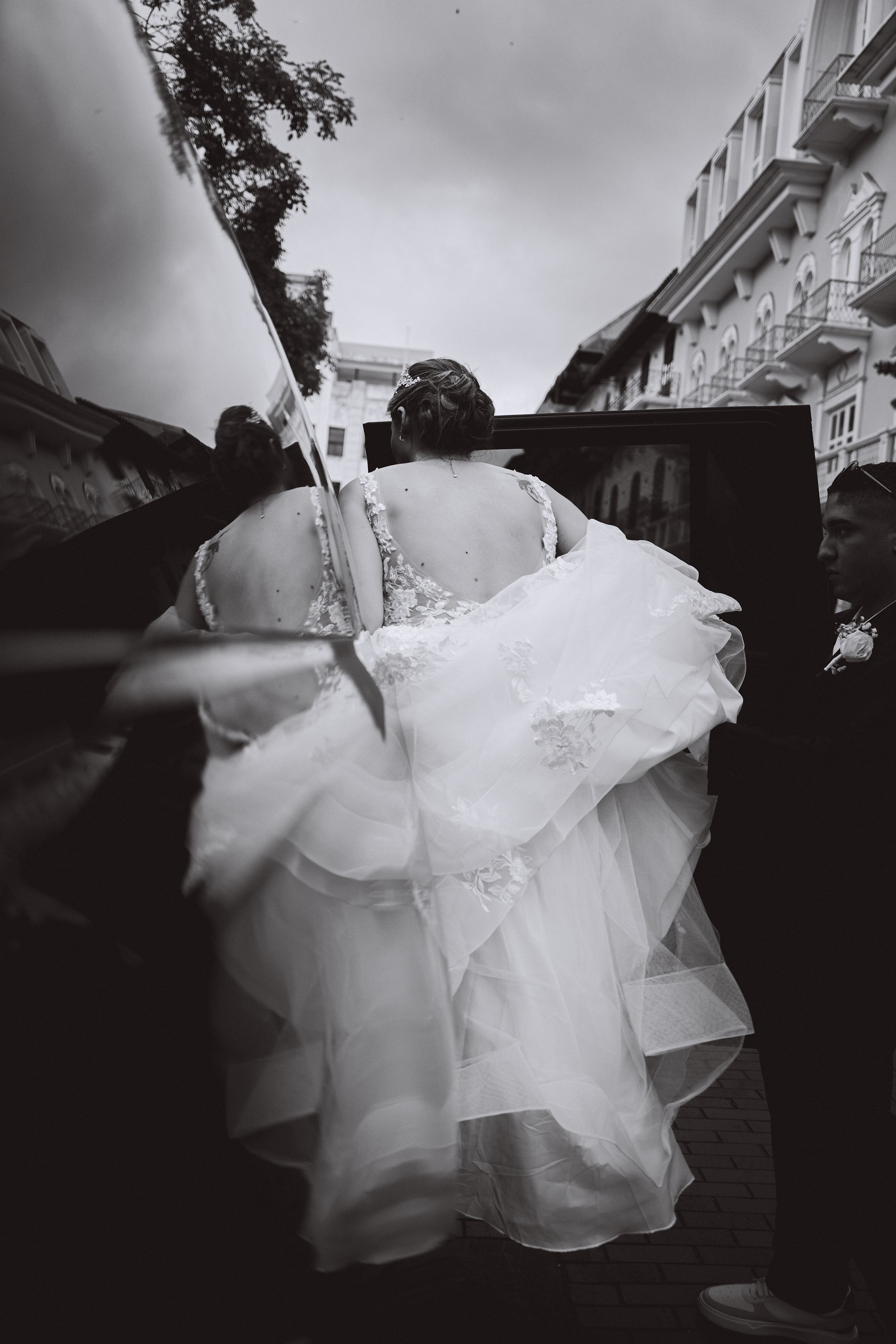 A black and white photo captures the flowing movement of a wedding dress from behind.