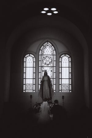 Black and white church window silhouette creating dramatic wedding ceremony composition.