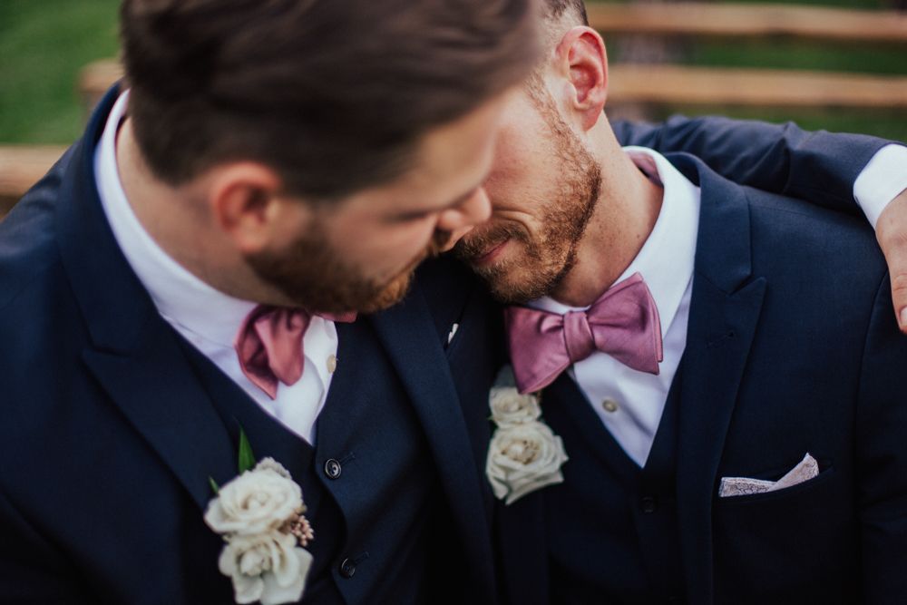 LGBT grooms sitting close together