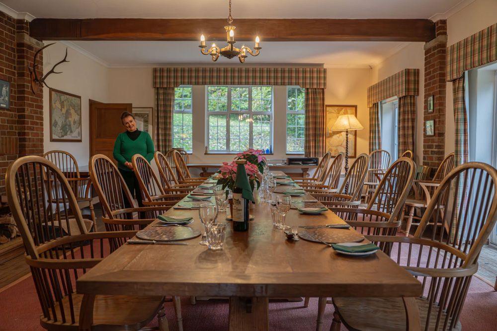 Formal dining room set with Windsor chairs and table settings in a country house.