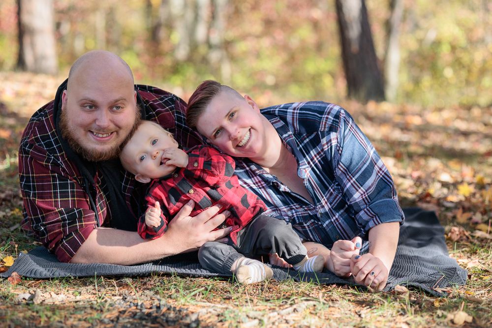 Group lying together on autumn leaves for casual outdoor portrait session.