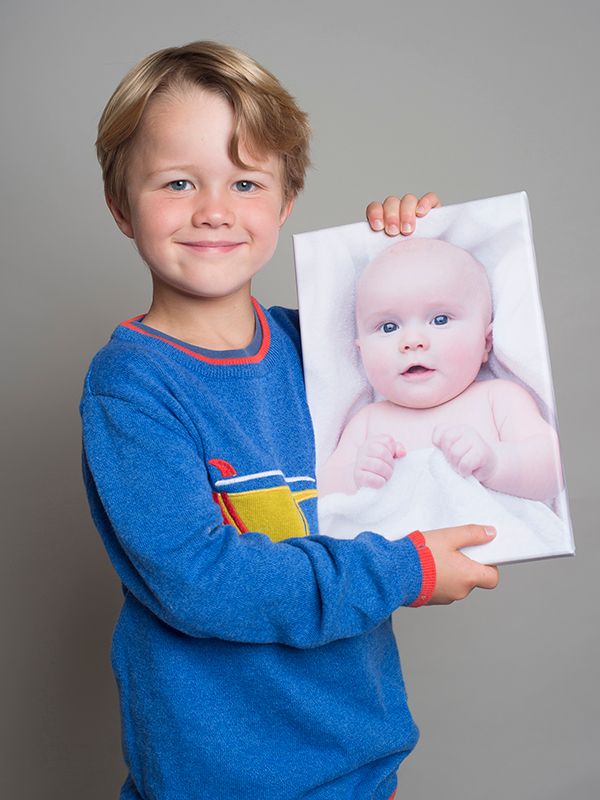 Boy holds his baby photograph on a canvas in professional photography session by Abigails Studio, High Wycombe