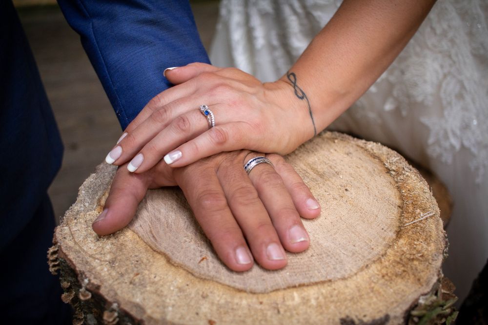 Hands and wedding bands on wood block