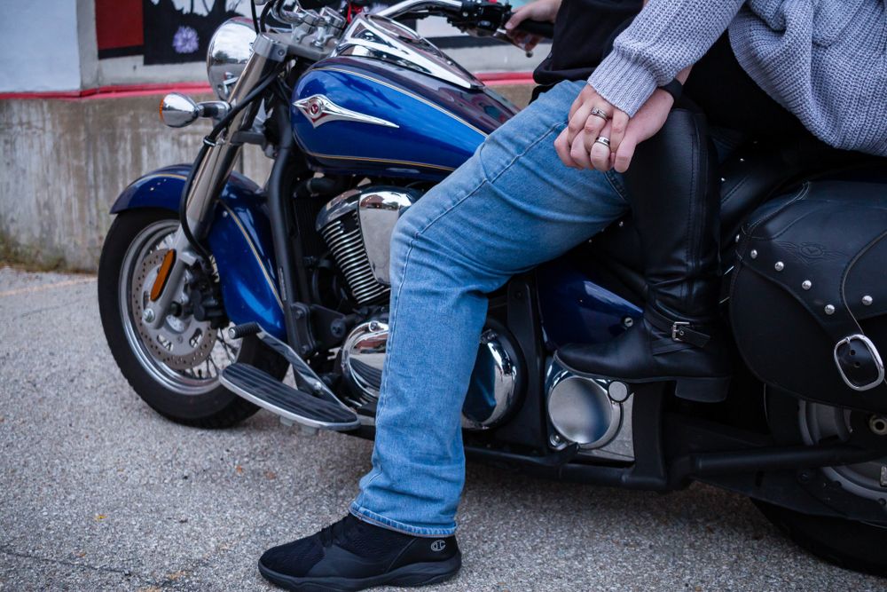 Couple holding hands on a motorcycle downtown