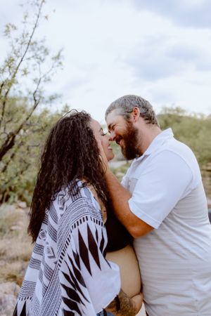 Romantic couple sharing an intimate moment against a desert mountain backdrop.