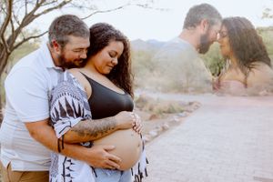 Couple in casual attire sharing tender moments in a desert setting during golden hour.