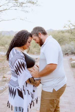 Intimate couple photoshoot in a desert landscape with mountains and natural lighting.