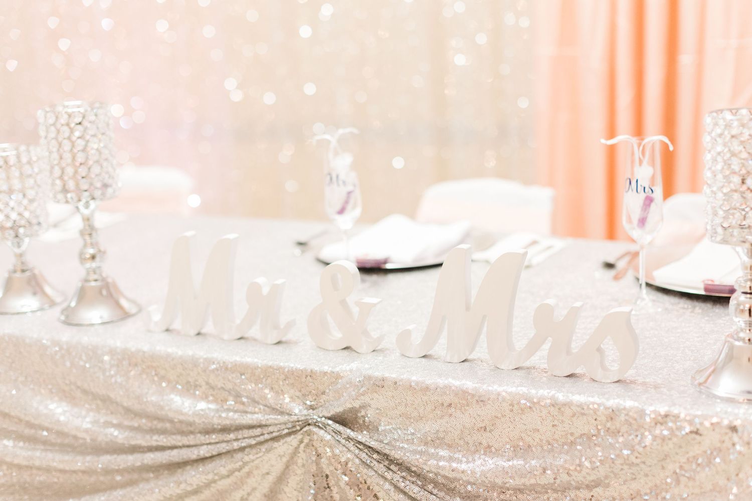 Elegant head table setup with crystal candelabras and sparkly tablecloth.