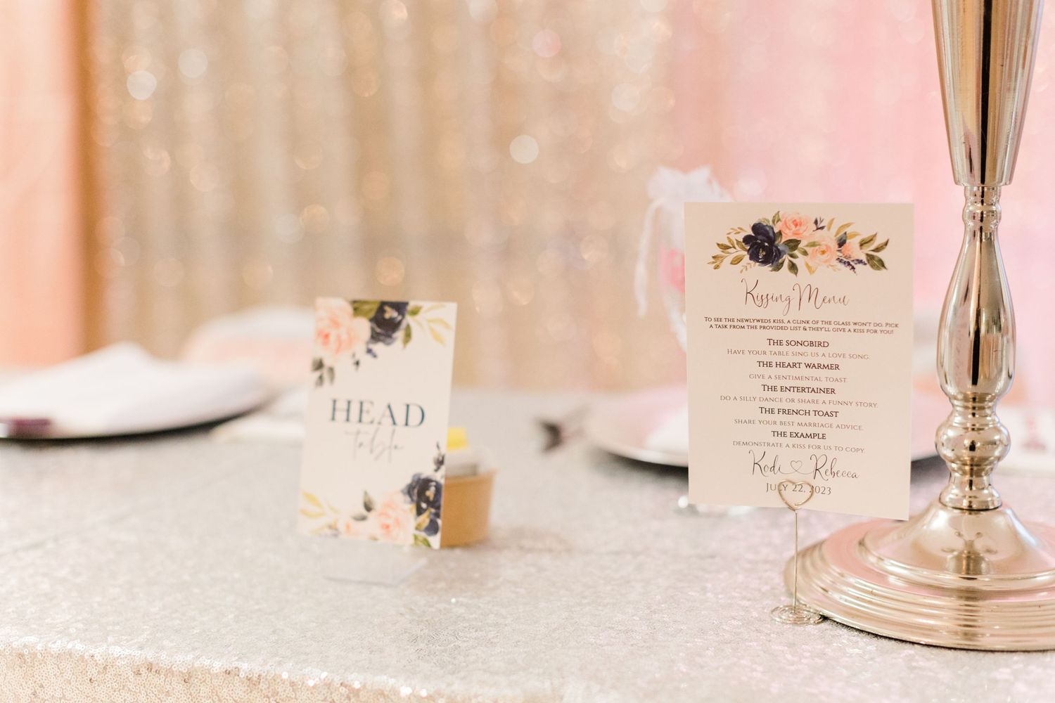 Wedding reception place cards on sparkly tablecloth with crystal candlestick.