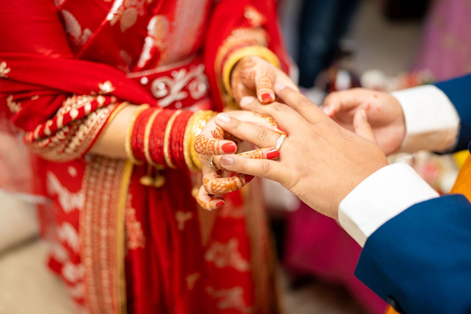 Close-up of hands during a traditional ring exchange ceremony.