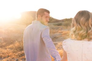 Romantic sunset scene with couple silhouetted against golden light.