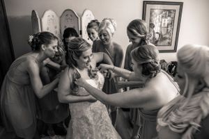 Black and white photo showing a tender moment of preparation before a wedding ceremony.