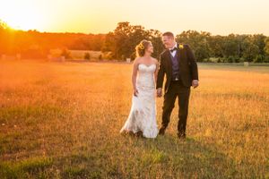 Sunset wedding portrait in a golden field with warm glowing light.