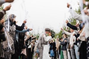 Joyful wedding celebration with guests throwing confetti at the newlyweds.