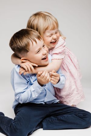 Two young children sharing a joyful laugh together.