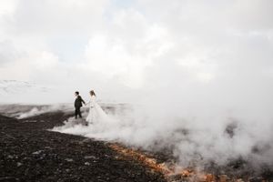 Silhouettes walking through dramatic misty volcanic landscape.