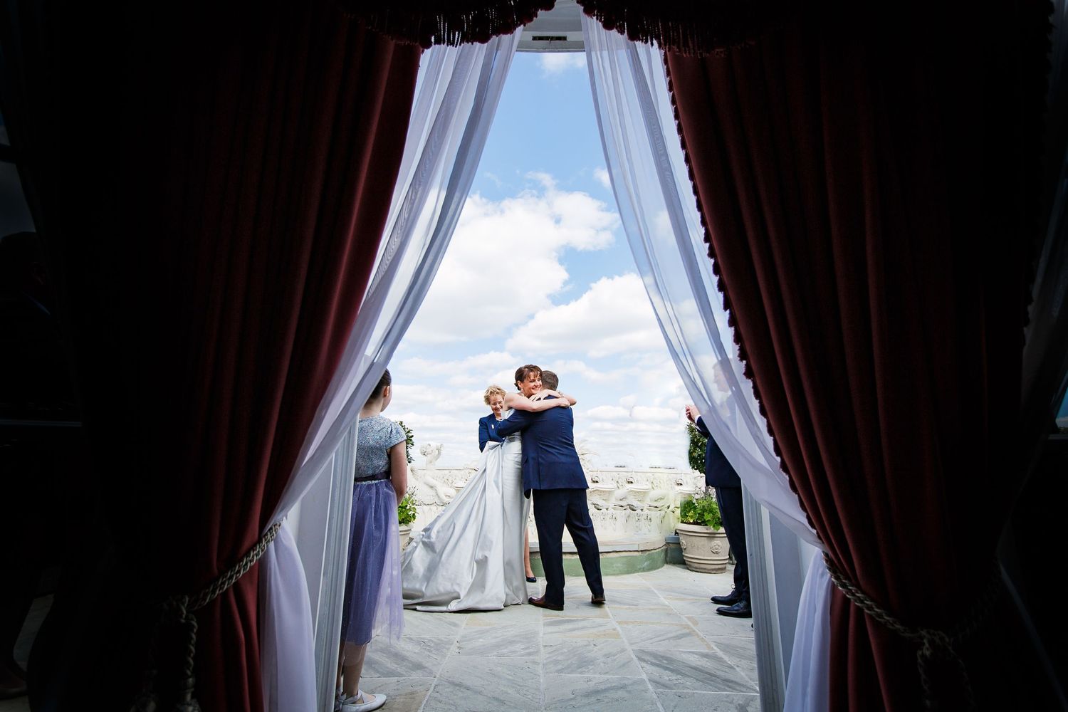 Newly-wed couple passionately embracing on terrace at Dorchester Hotel