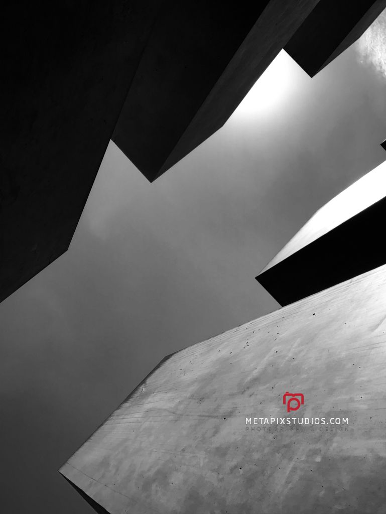 Black and white low angle shot of angular concrete architectural structures.