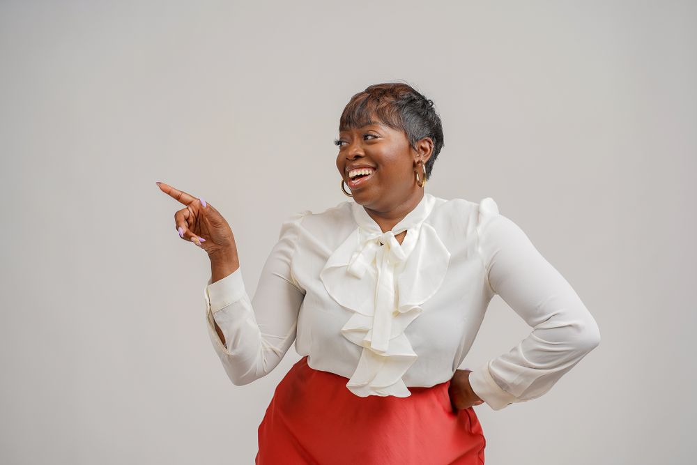 Energetic poses in white ruffled blouse against light studio background.