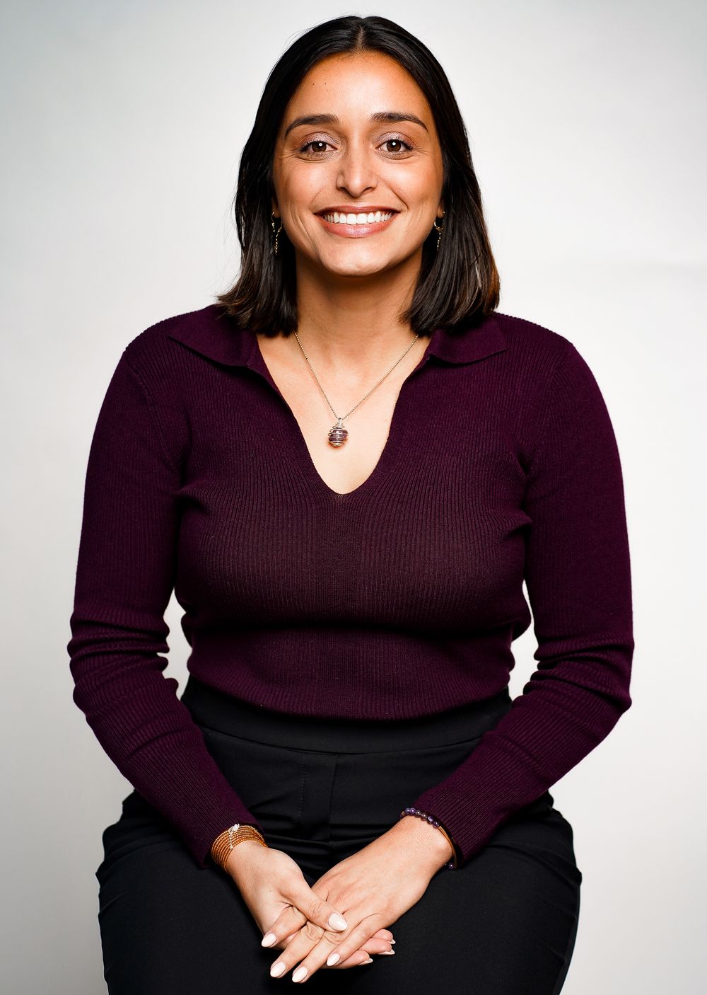 Professional studio portraits showing person in burgundy sweater and black pants against white background.
