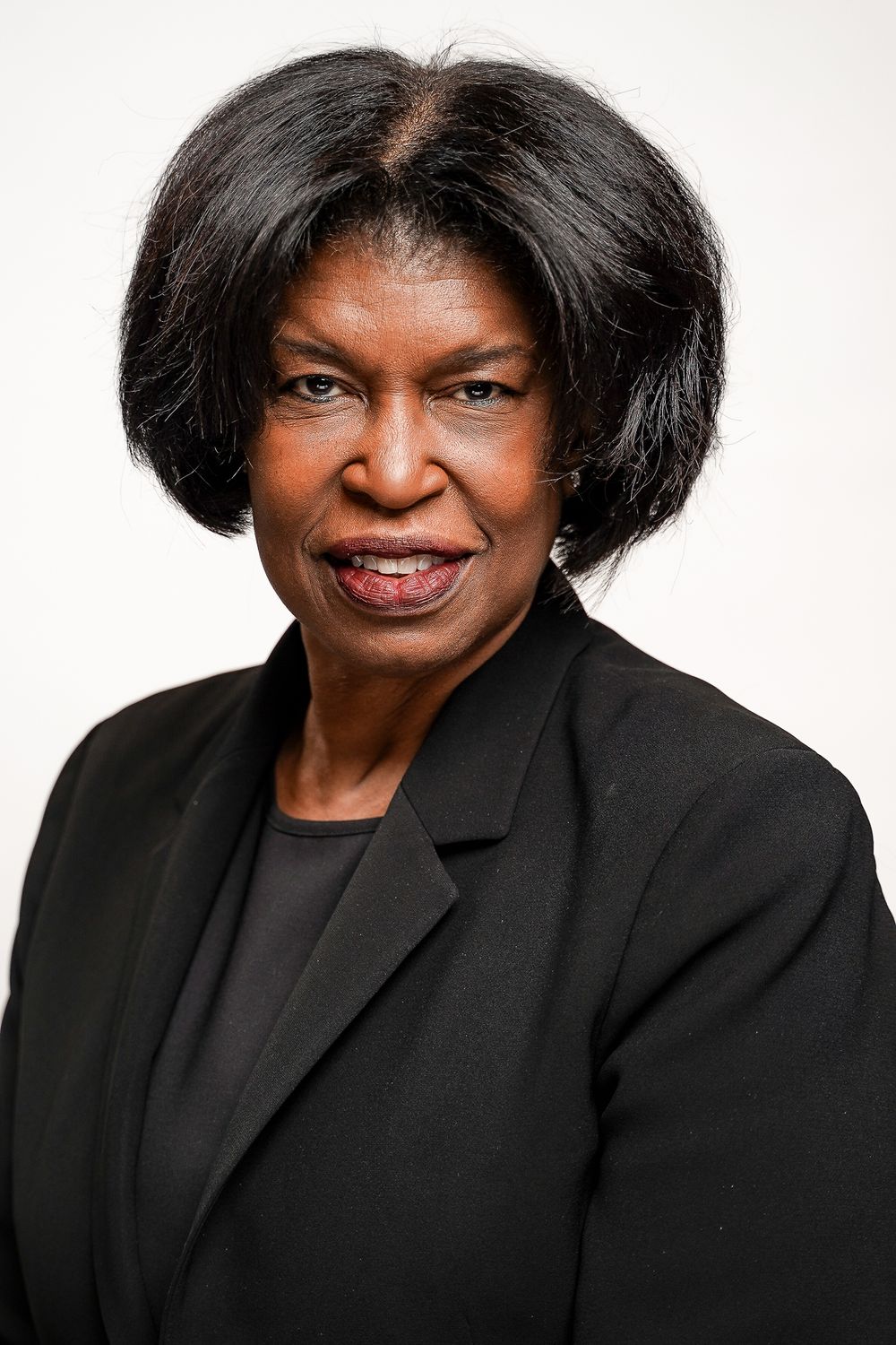 Professional headshots showing person in black blazer against white background.