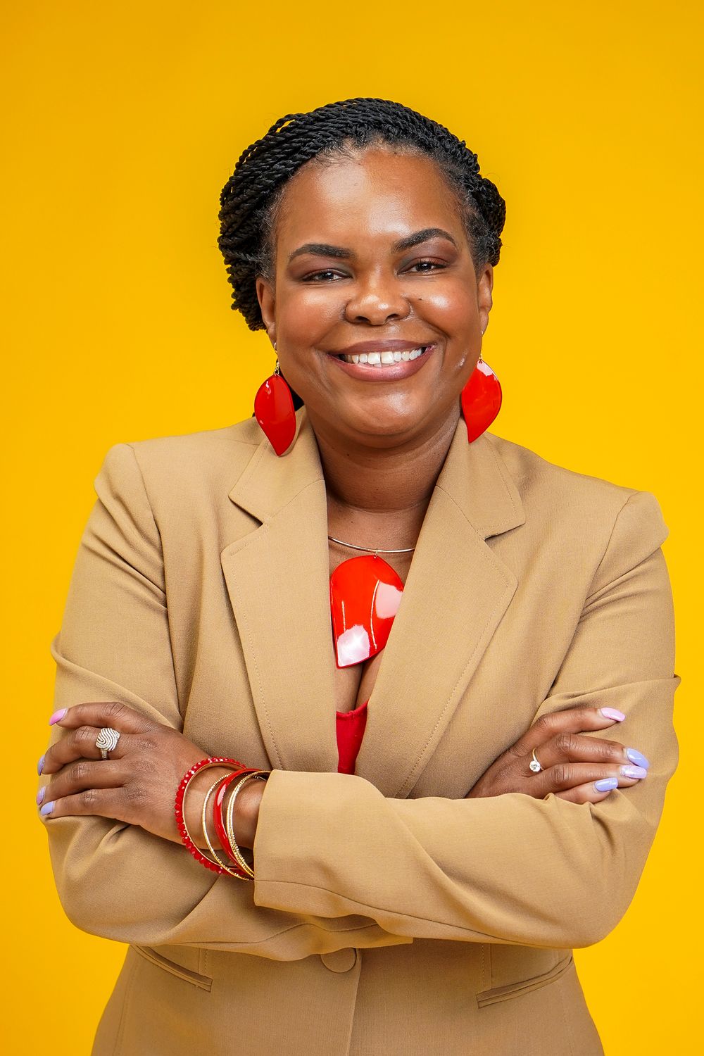 Professional headshots of a person in a tan blazer and red top against a vibrant yellow background.