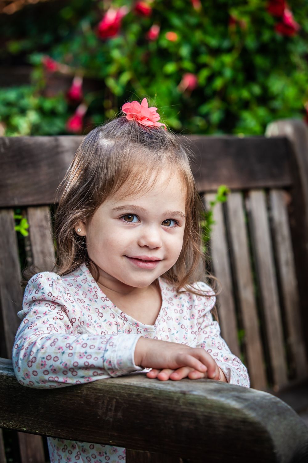 A series of charming garden bench portraits featuring floral clothing and natural outdoor lighting.