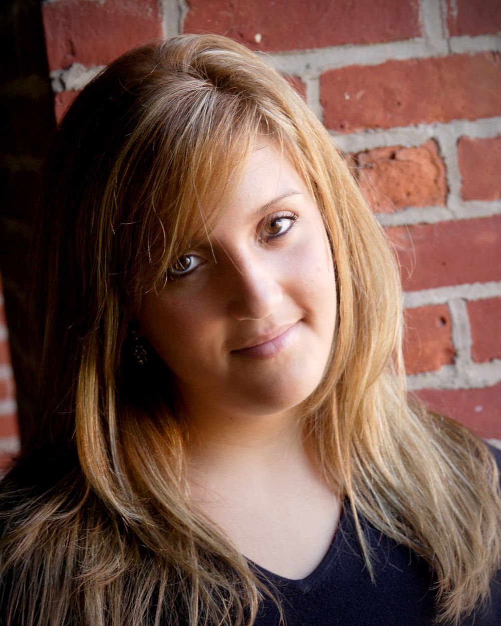 A series of artistic portraits against a brick wall background showing playful expressions and poses.