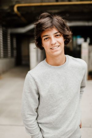 Person wearing light gray sweatshirt sitting casually indoors.