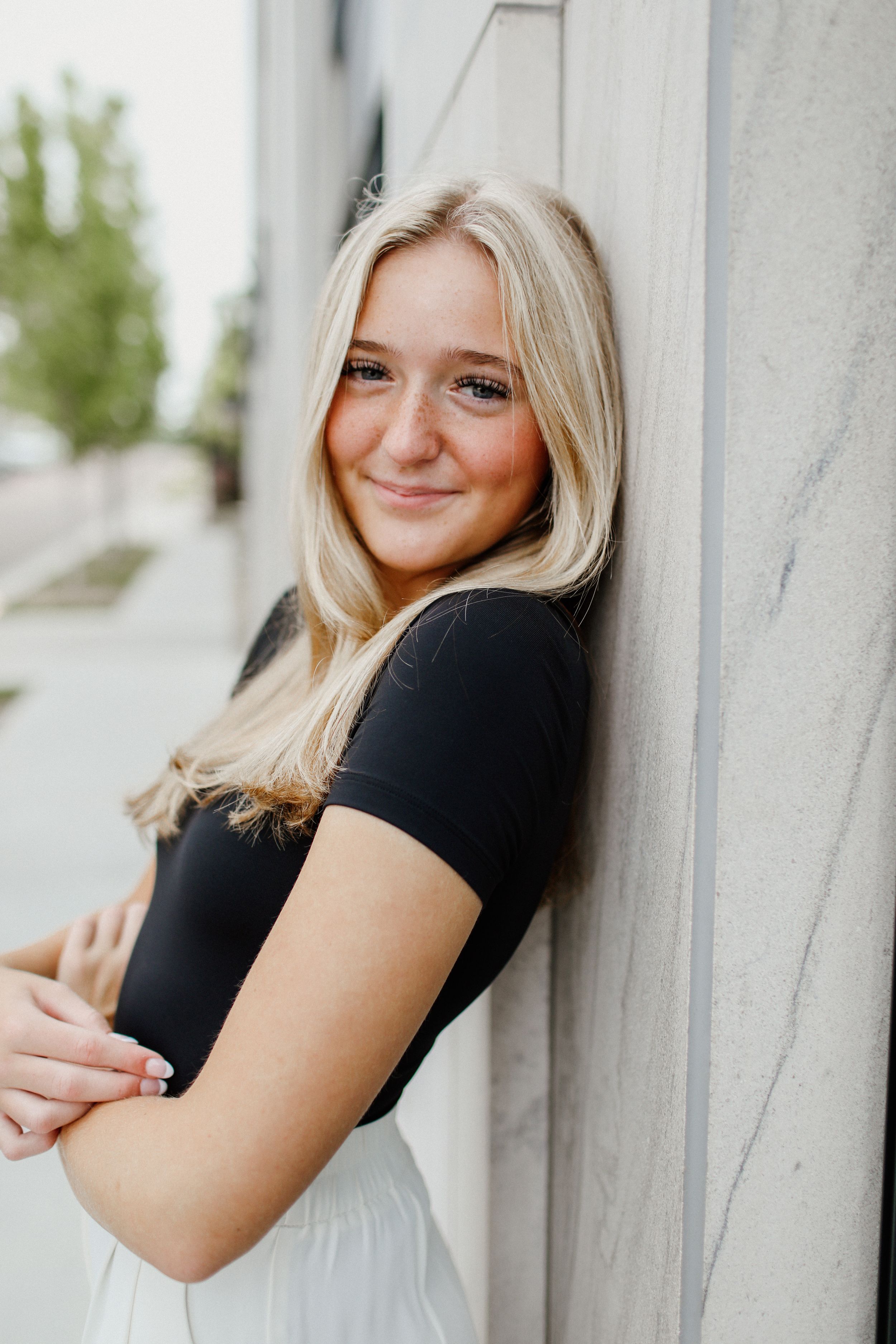 Portrait series against white wall showing casual poses.