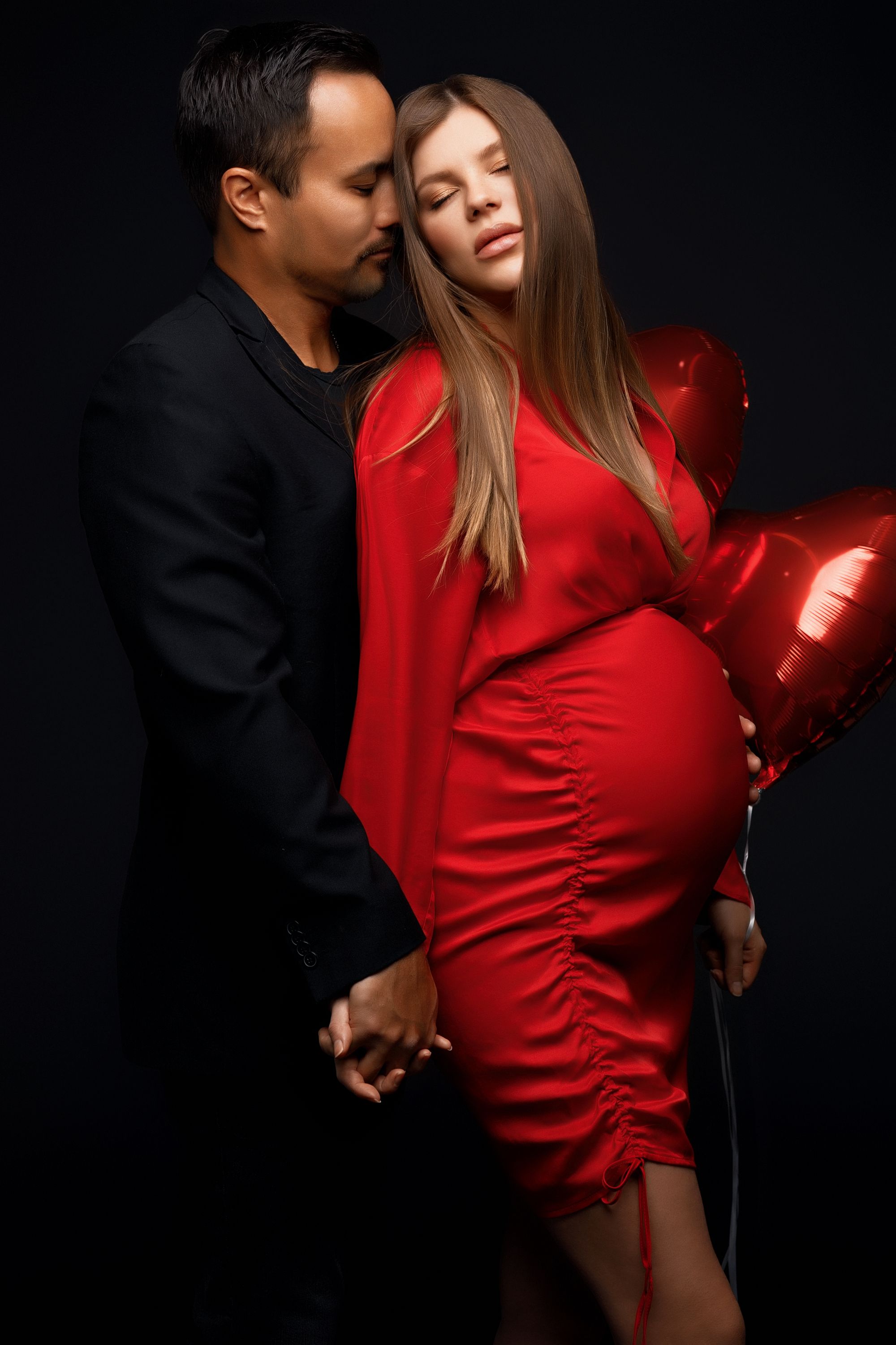 San Diego Valentine's Day maternity session with a partner holding heart shaped balloons, captured by Daryana Orange.
