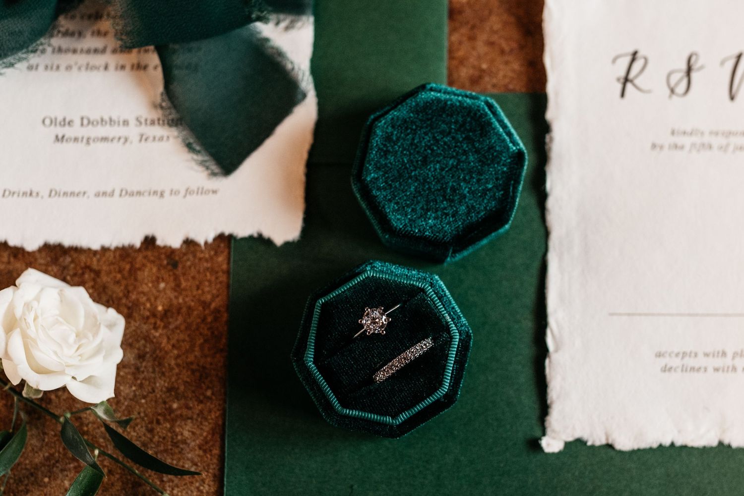 Wedding stationery and emerald velvet ring box with delicate paper details.