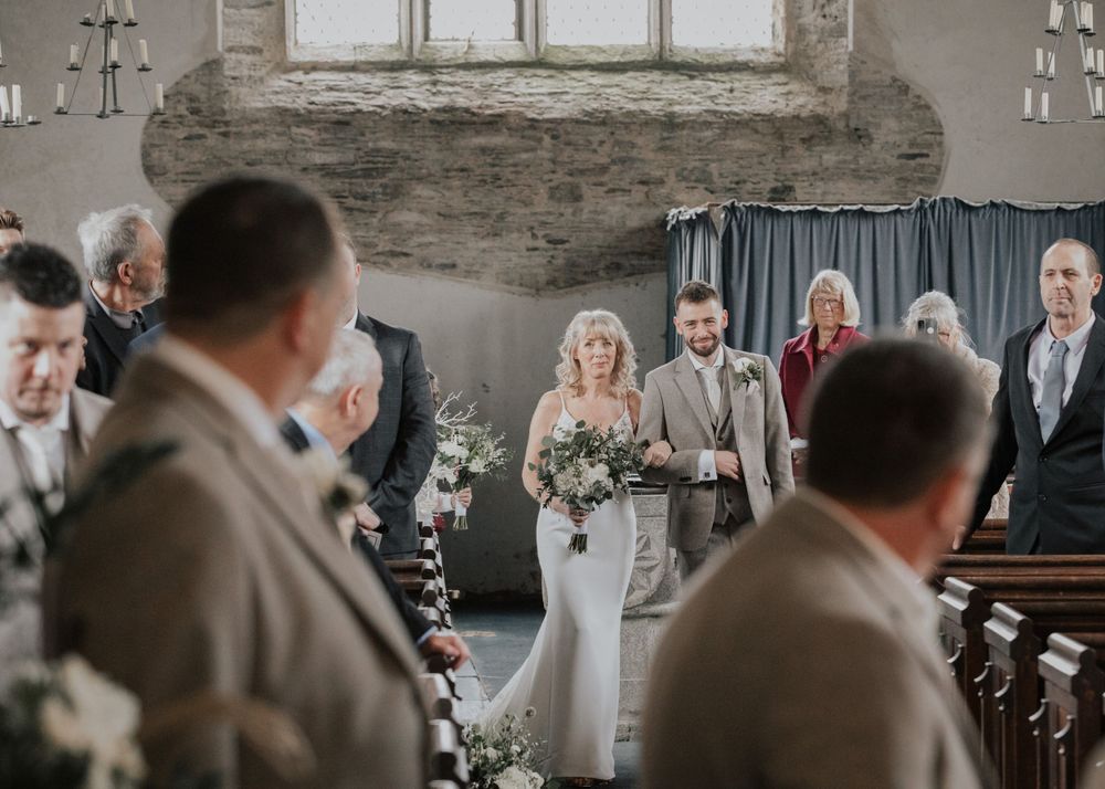 groom watching bride walk down the aisle photography