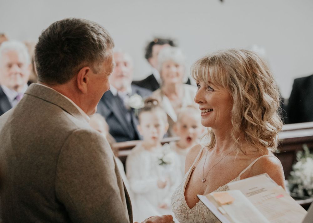 bride and groom say vows in a church in Cornwall