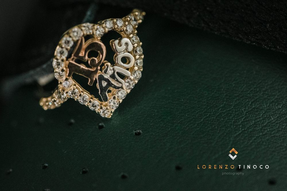 Intricate diamond crown-shaped ring with delicate filigree details on dark green leather.