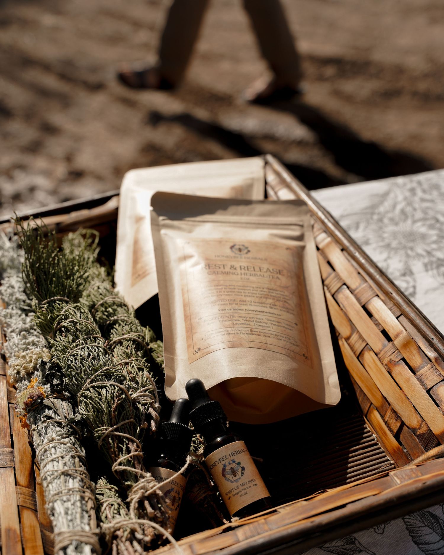Woven basket containing dried herbs, pouches and aromatherapy products photographed from above.