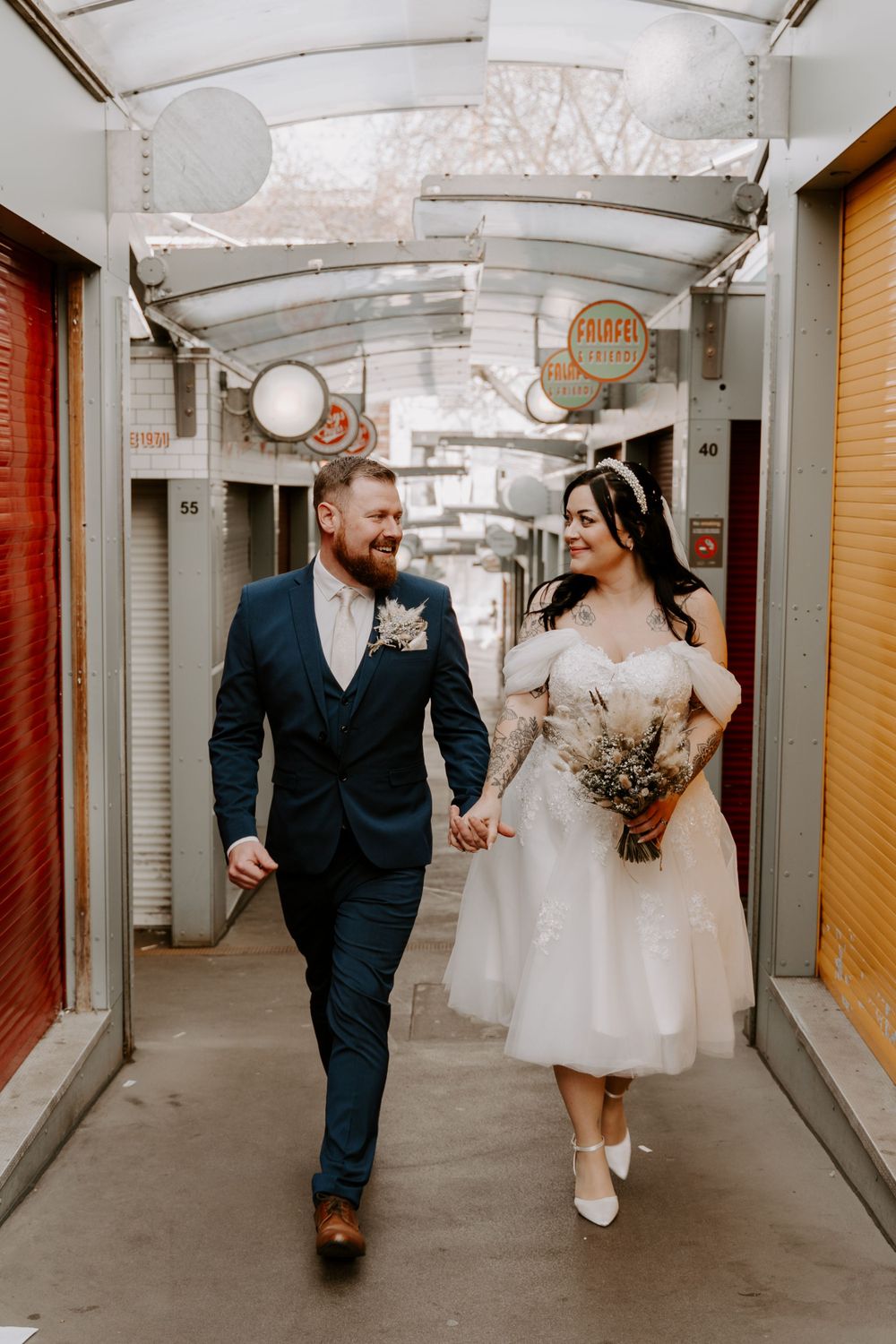 Bride and groom walking through the market stalls in norwich city centre.