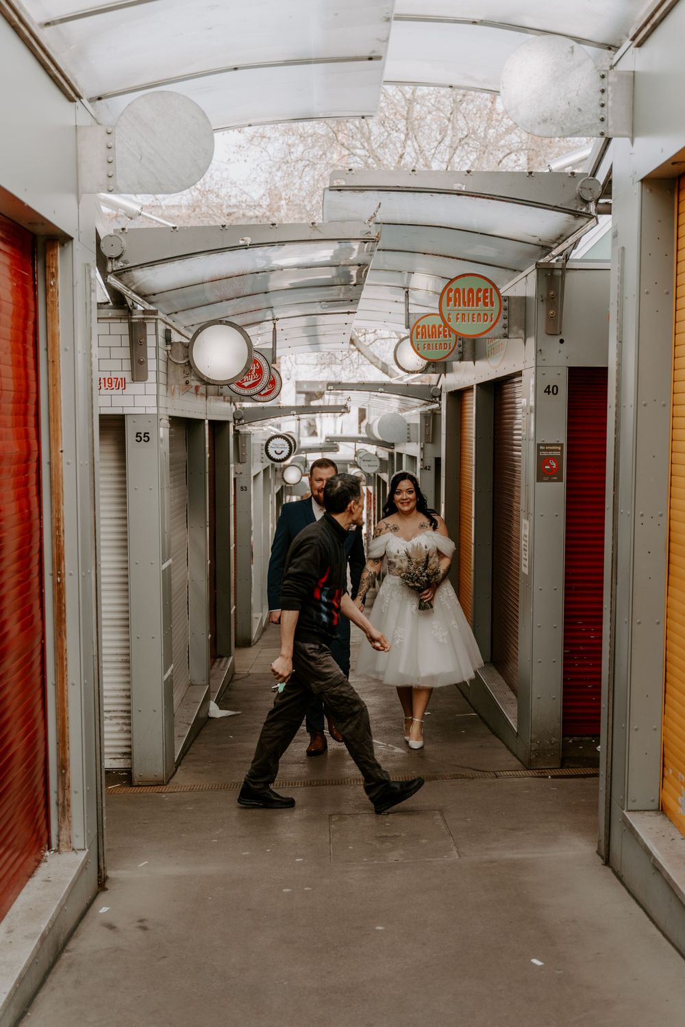 Bride and groom walking through the market stalls in norwich city centre.