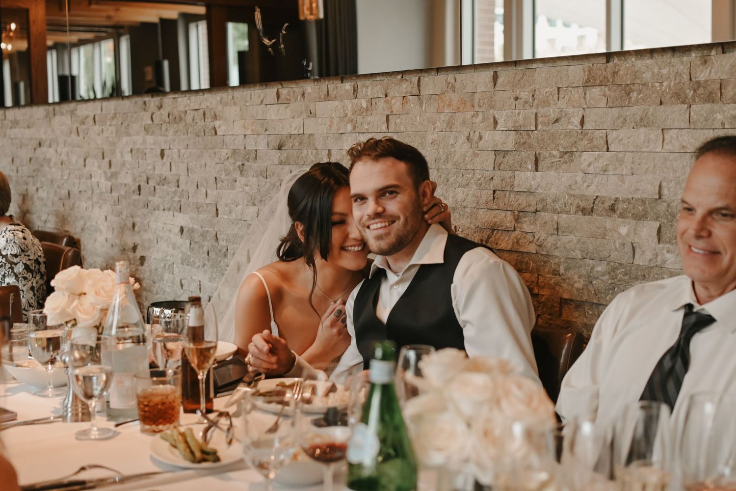 Wedding reception celebration in a rustic venue with exposed brick walls.